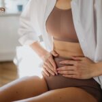 Fizjoterapia w endometriozie - kobieta trzymająca się za brzuch